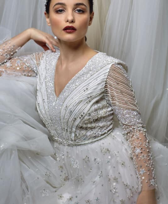 bridal makeup look with berry lips sleek bun for a wedding bride wearing long sleeve dress