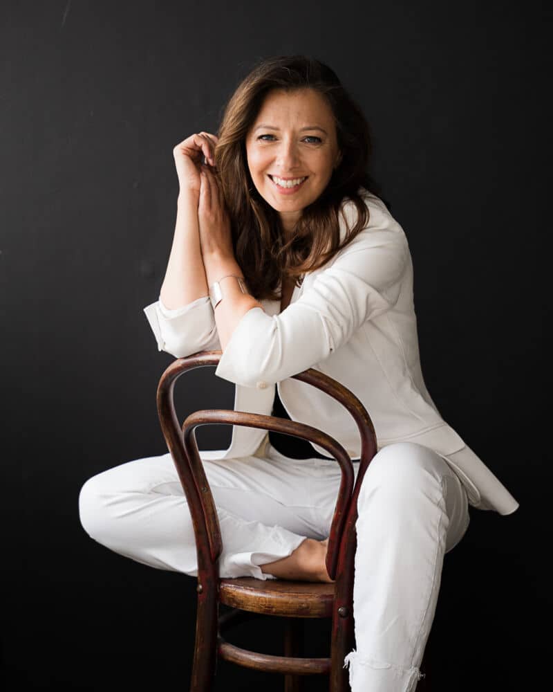 woman sitting on the chair wearing white suit
