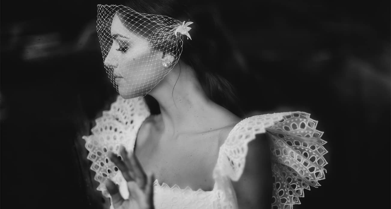 Bride wearing birdcage veil wedding headpiece and soft natural modern makeup