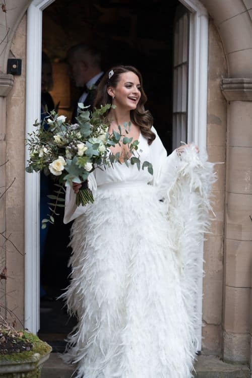 ostrich Bride wearing feather skirt wedding dress leaving the venue