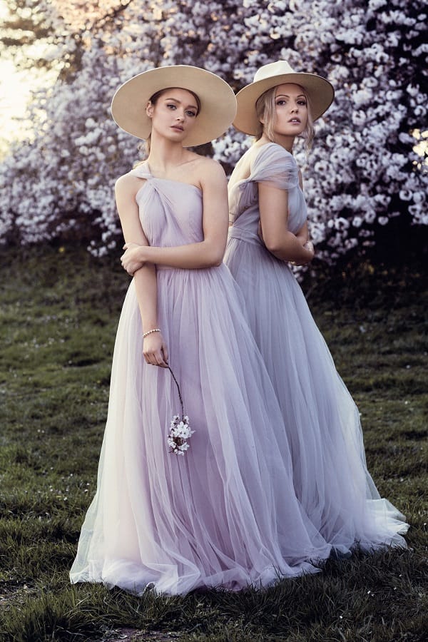bridesmaids in light purple dresses in a garden wearing natural makeup